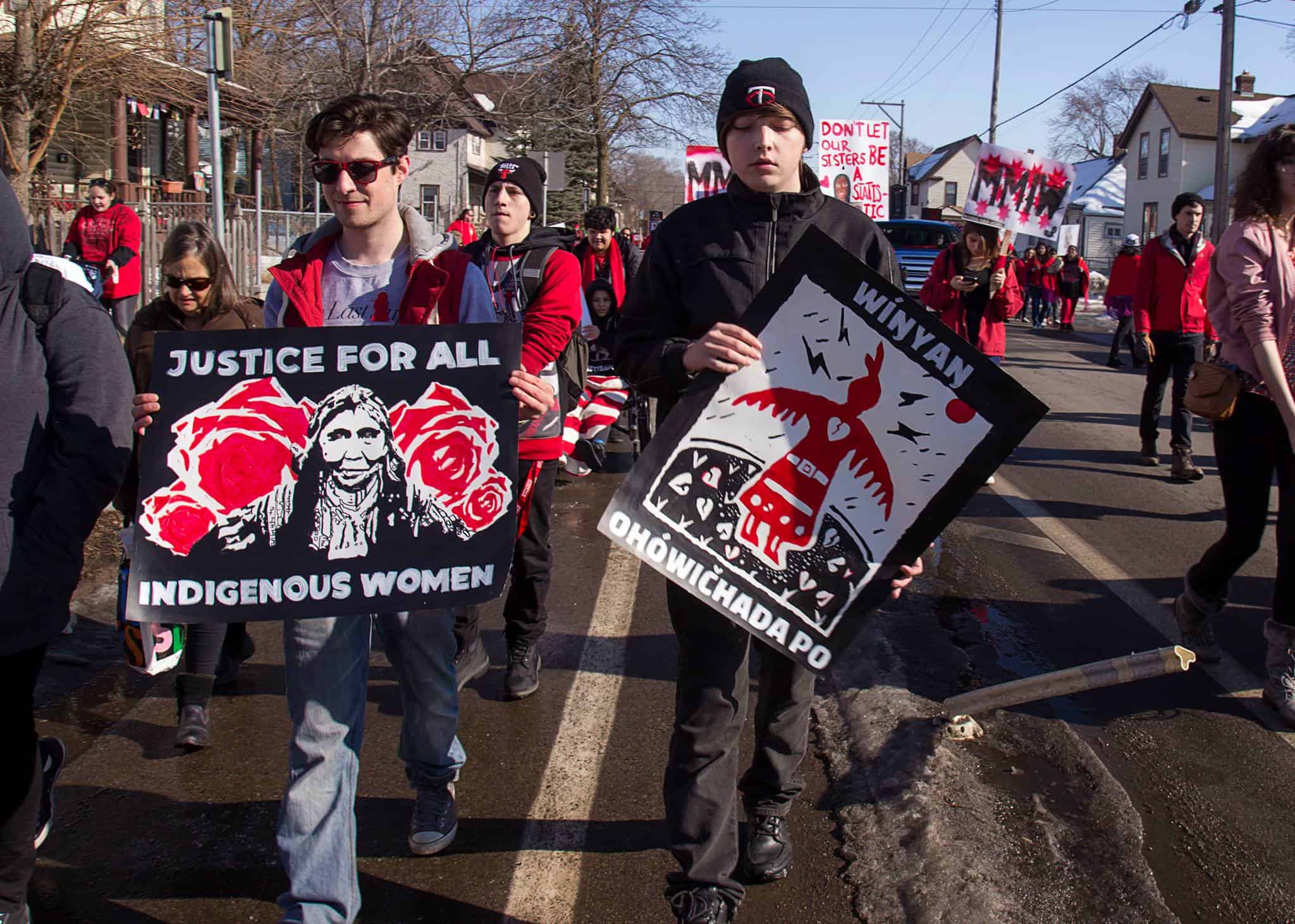 Men holding signs calling for justice for all indigenous women
