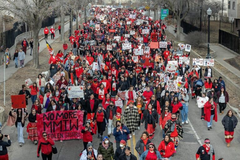 People marching for Missing & Murdered Indigenous Relatives in Minneapolis, MN 2024; most people wear red.